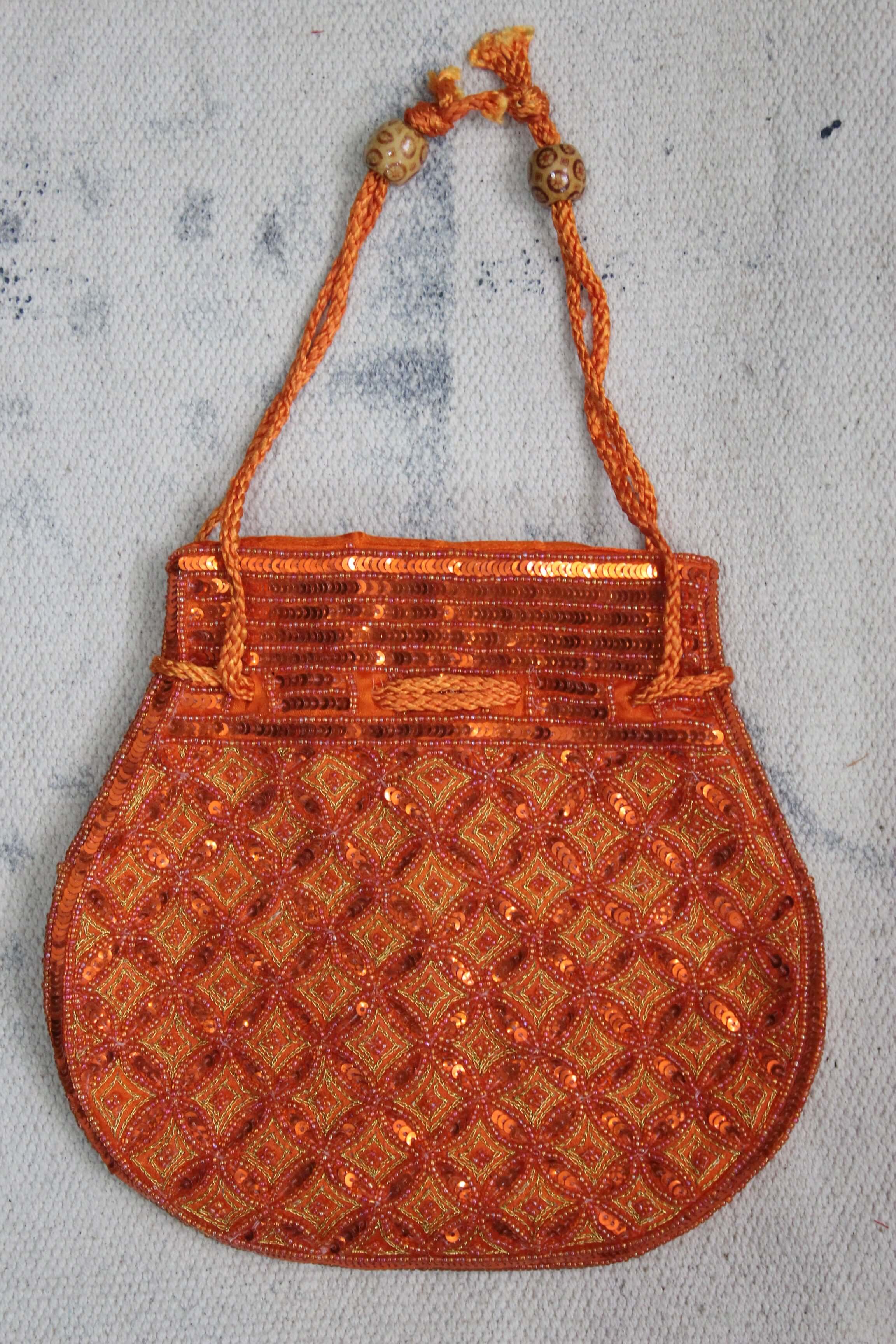 Beautiful orange handmade potli bag with sequins, ideal for fashion and carrying small articles.